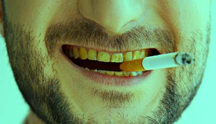 желтые зубы с сигаретой